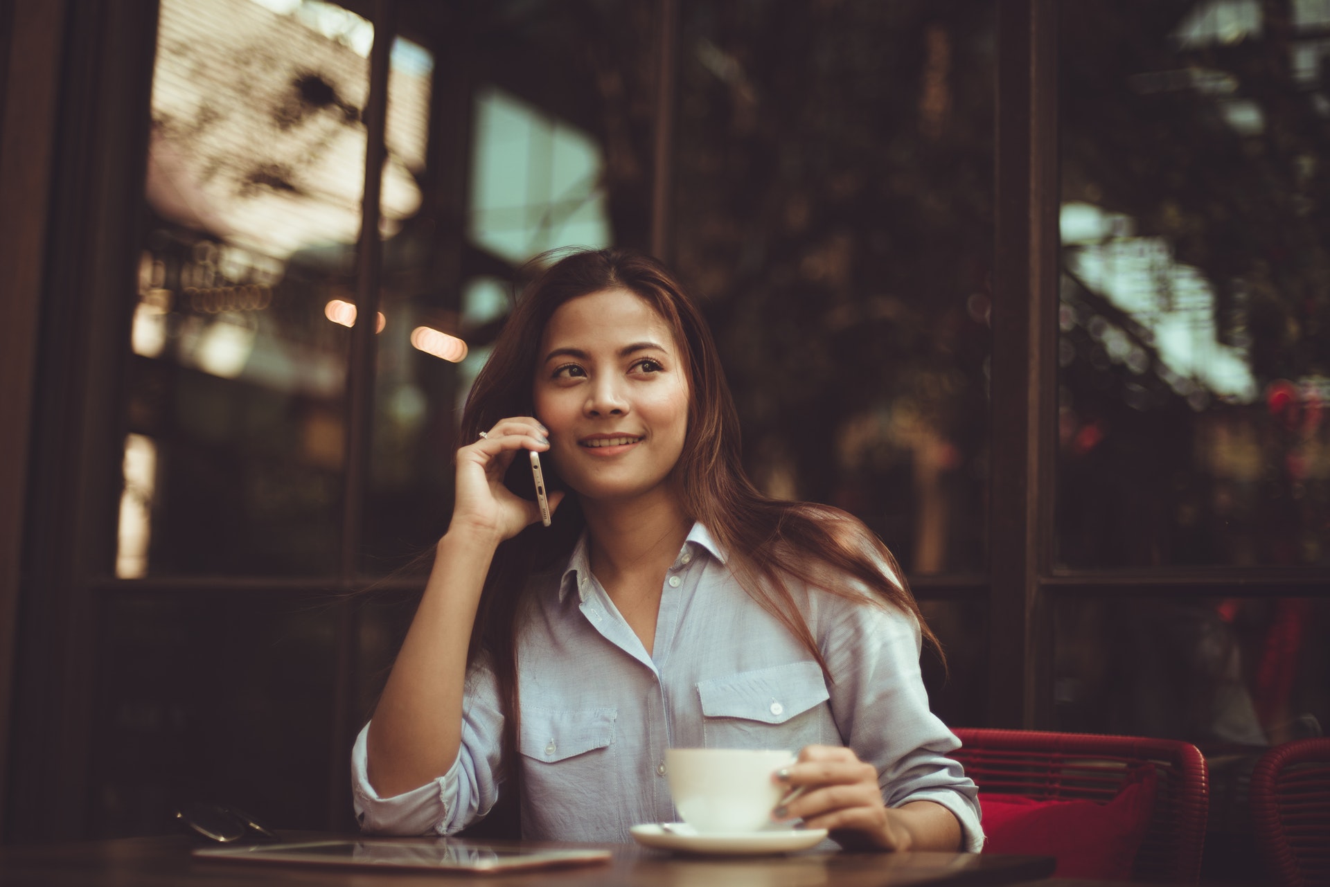 Woman using mobile phone in Cafe Contact